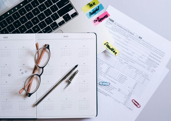 Organized workspace featuring a calendar, tax documents, and planner essentials.